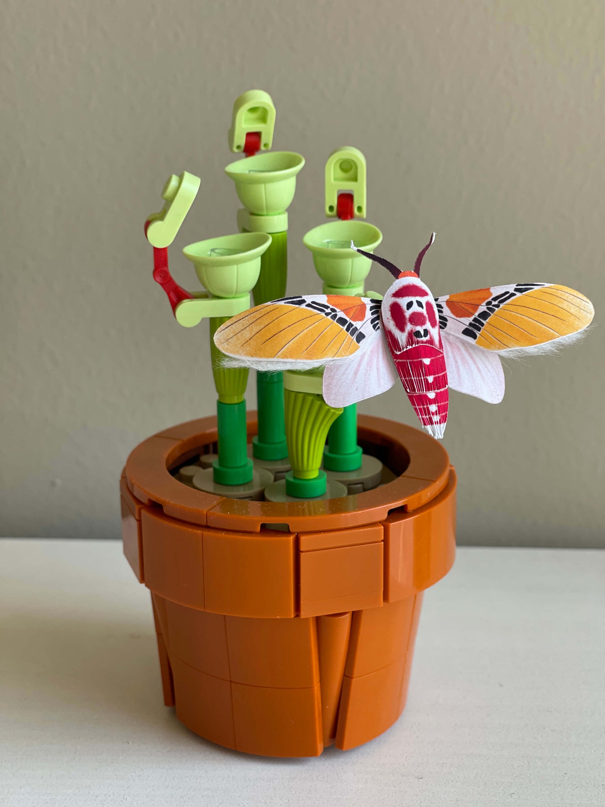 Paper Moth, Paper Clown Face Moth staying on a lego plant