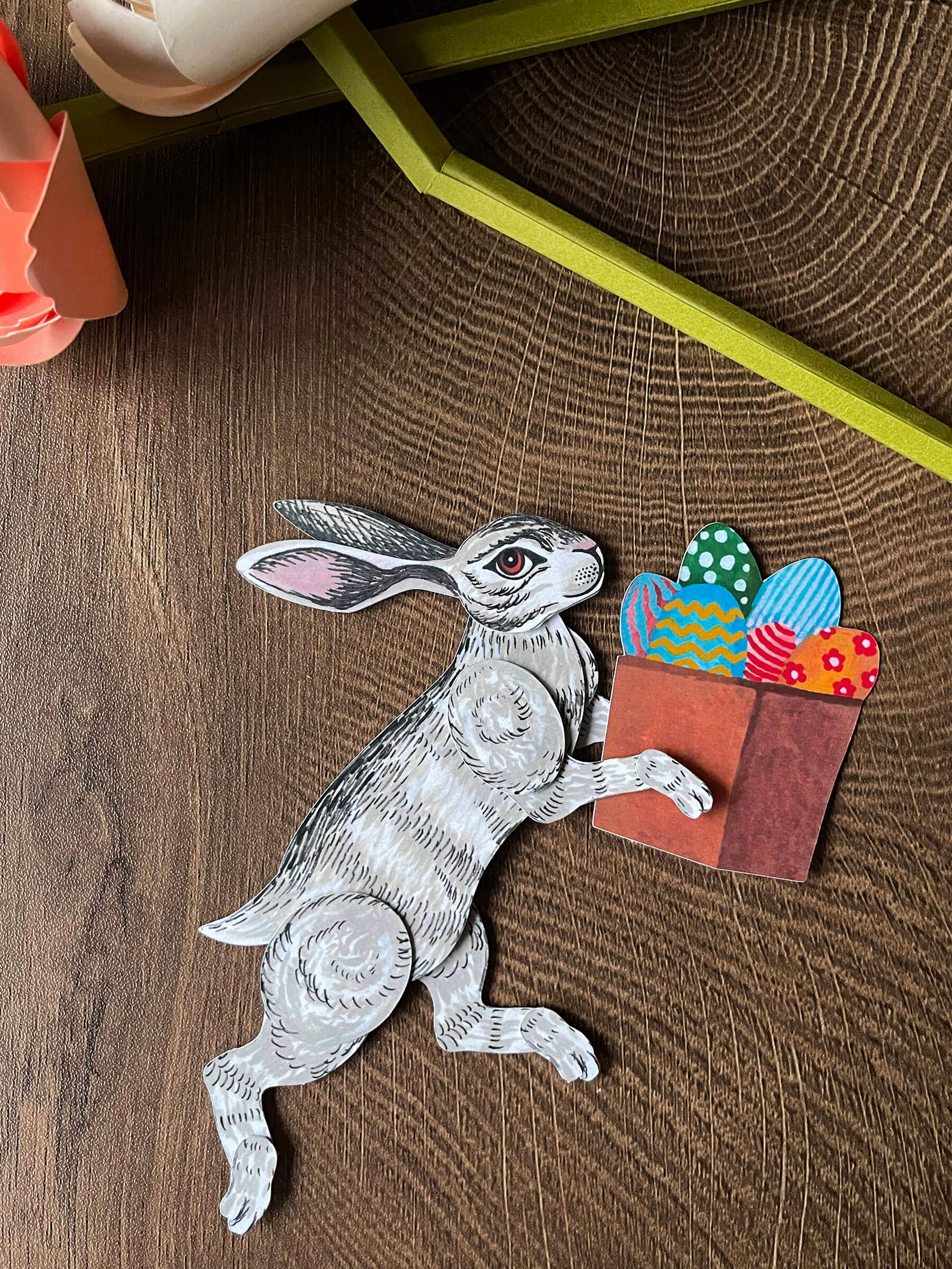 Easter decor of a bunny paper doll holding a box of Easter eggs