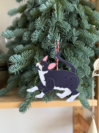 Decorative Christmas ornament of a Devon Rex Paper Doll hanging on a tree